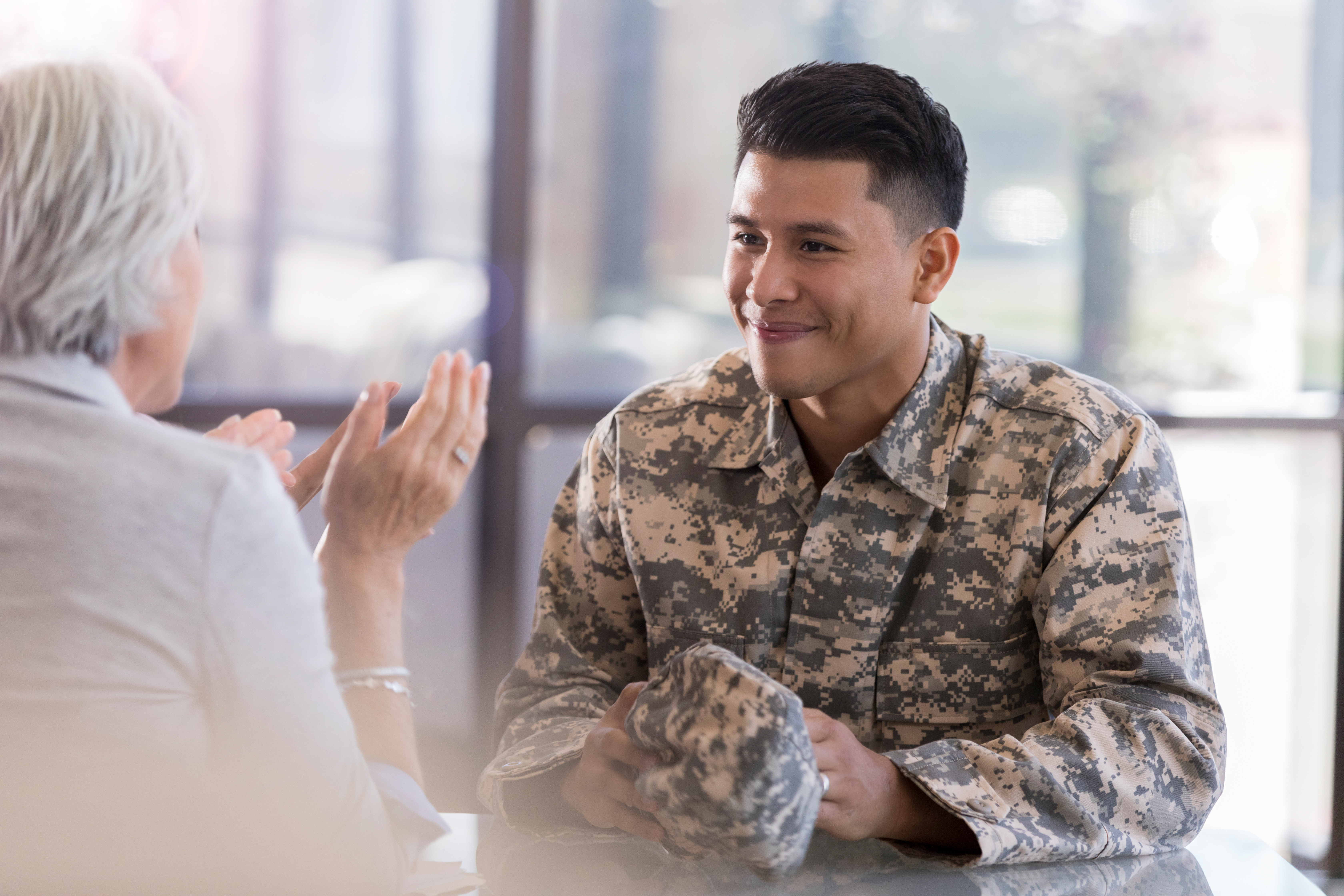 Veteran in uniform speaking with a career counselor.
